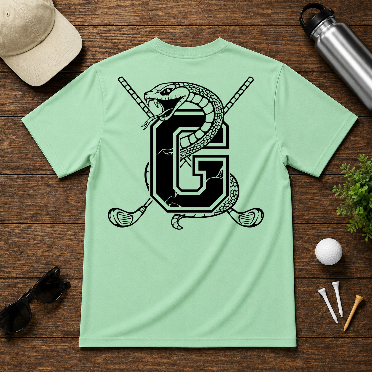 Varsity style golf shirt with a snake wrapped around the letter "G", with a pair of golf clubs in the back.