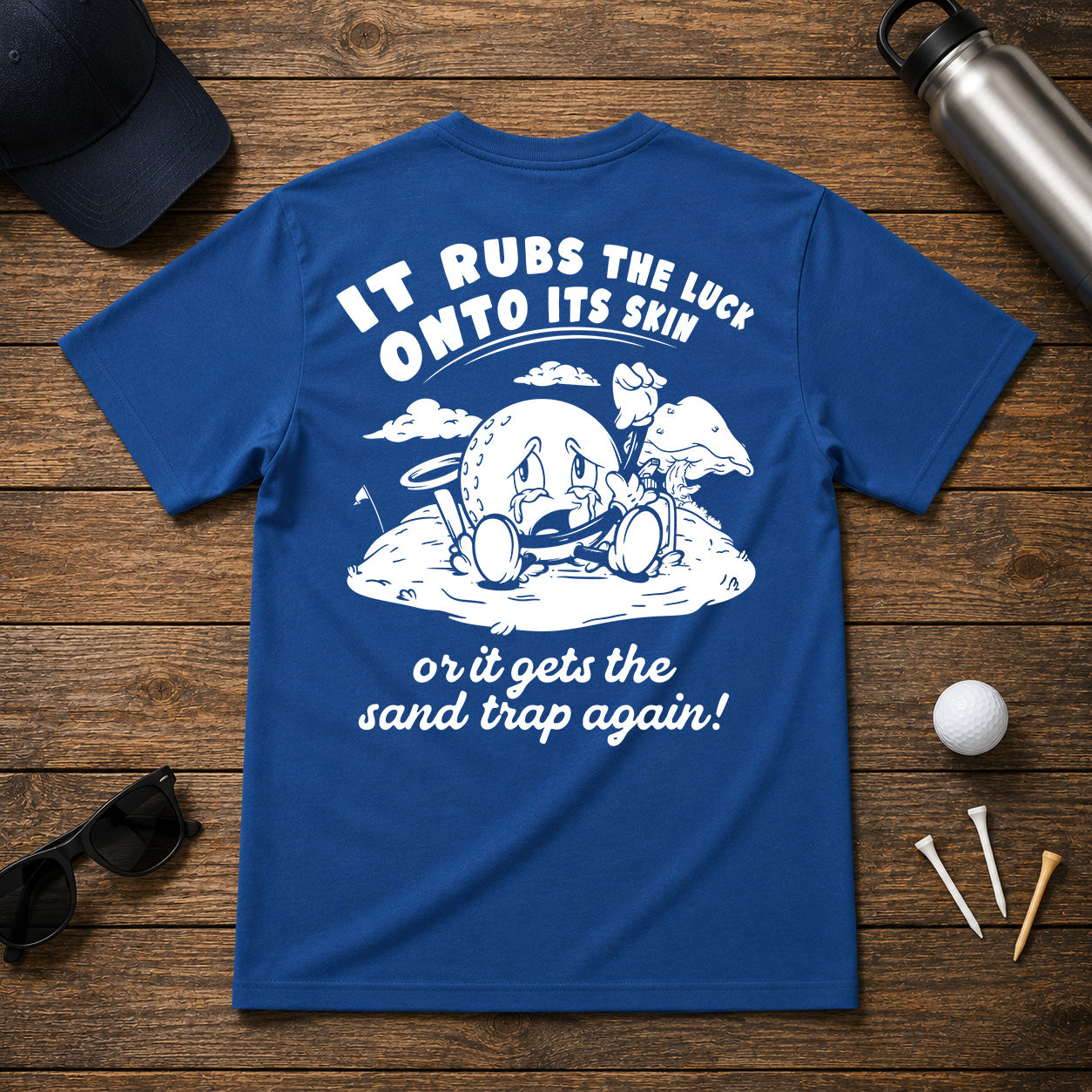 It Rubs The Luck Onto Its Skin- Funny sarcastic joke shirt for golfers that have bad luck on the golf course. Funny golf ball character rubbing luck lotion in itself, in hopes of getting to the hole.